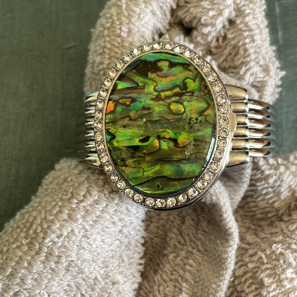Genuine abalone hidden watch on a silver cuff.
